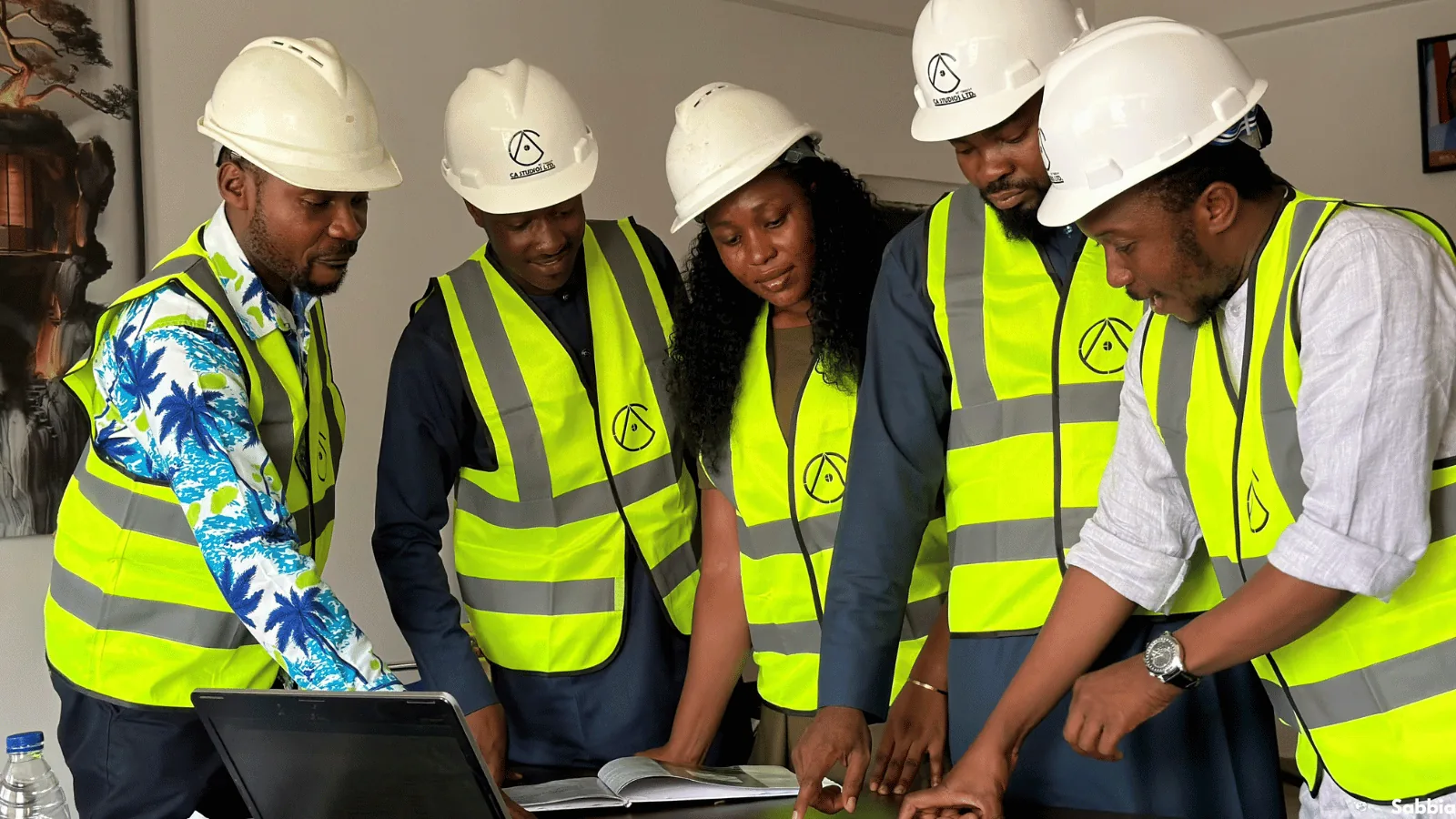 Project team in site safety wear reviewing development plans together